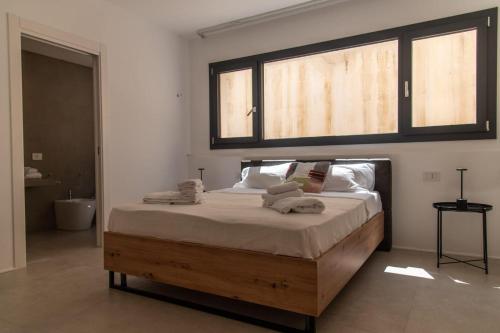 a bed in a bedroom with a large window at Tenuta Rapillo in Castellammare del Golfo