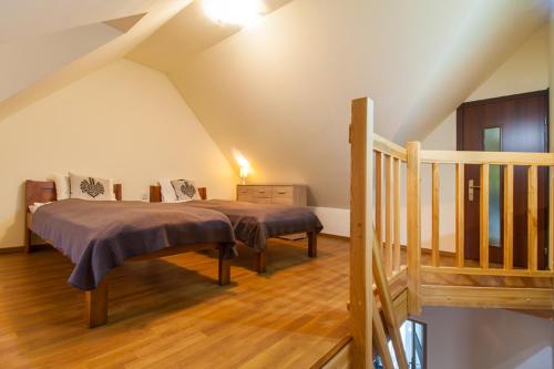 a bedroom with a bed and a staircase in a attic at Pod Reglami in Krościenko