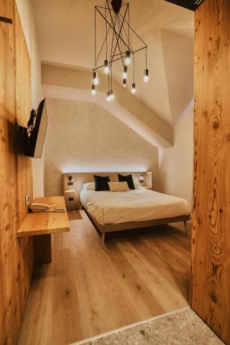 a bedroom with a bed and a chandelier at Albergo Meublè Vecchio Scarpone in Baceno