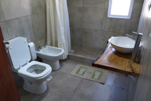 y baño con aseo y lavamanos. en Cabañas Tío Joe en San Antonio de Arredondo
