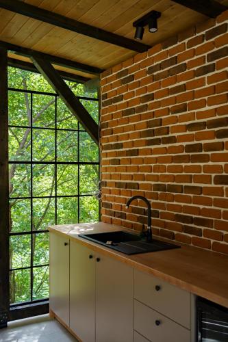 a kitchen with a sink and a brick wall at True Cabin in Sovata