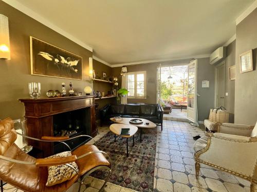uma sala de estar com mobiliário de couro e uma lareira em La Maison de Fabienne em Tarascon