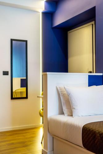 a bedroom with a bed with a blue wall at The Dorians in Athens