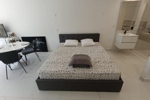 une chambre avec un lit, une table et un lavabo dans l'établissement Naturiste Cap d'Agde Héliopolis O 11, au Cap d'Agde