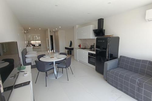 une cuisine et un salon avec une table et un canapé dans l'établissement Naturiste Cap d'Agde Héliopolis O 11, au Cap d'Agde