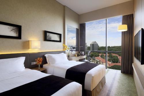 a hotel room with two beds and a large window at Park Hotel Alexandra in Singapore