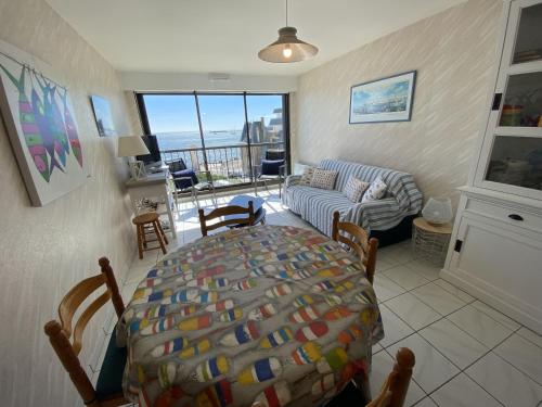 un salon avec une table et un canapé dans l'établissement Studio face mer - PROCHE PLAGE - Quartier Arago, à Les Sables-dʼOlonne