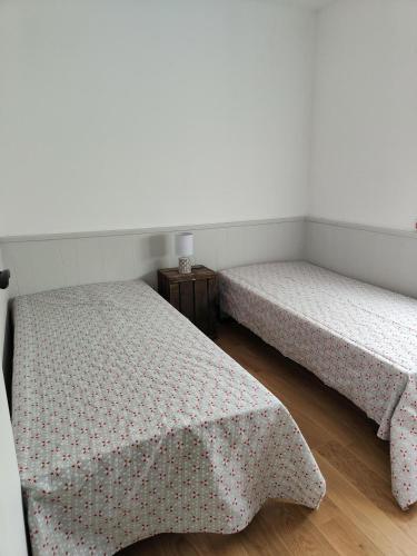 - 2 lits dans une pièce avec une table dans l'établissement Frontignan villa rez de chausée avec exterieur privatif, Plage 4km, à Frontignan