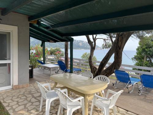 una mesa y sillas en un patio con vistas al agua en Hamre Apartments (Nicholas), en Agios Georgios Pagon