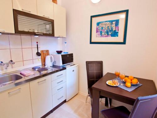 a small kitchen with a table with oranges on it at Center Magnifique apartment, OLD TOWN in Split