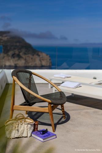 a chair sitting on a deck with a table at Hacienda Na Xamena, Ibiza in Na Xamena