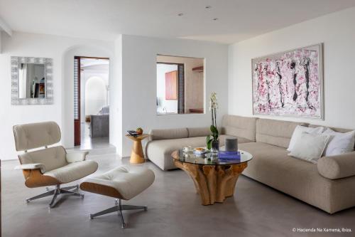 a living room with a couch and a table and chairs at Hacienda Na Xamena, Ibiza in Na Xamena