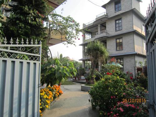 une maison avec une clôture et des fleurs devant elle dans l'établissement New Annapurna Guest House, à Pokhara