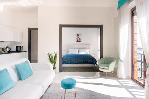 a white room with a bed and a white couch at Babylon Luxury Suite & Apartments in Naples