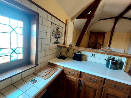 a kitchen with a sink and a window in it at Au Jardin Secret proche Center Parcs in Pouançay