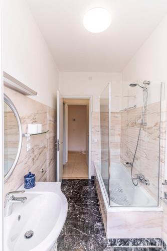 a bathroom with a white sink and a shower at Quattro Fontane Apartment in Venice-Lido