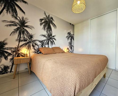 um quarto com uma cama com palmeiras na parede em Superbe Apt 2 ch, terrasse, WIFI, parking gratuit em Toulouse