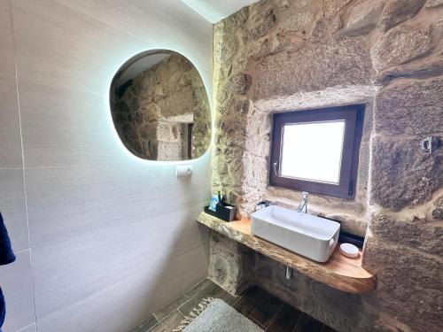 a stone bathroom with a sink and a mirror at Chalet con piscina Gondomar in Gondomar