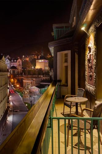 a balcony with a table and a view of a city at EA Hotel Atlantic Palace in Karlovy Vary