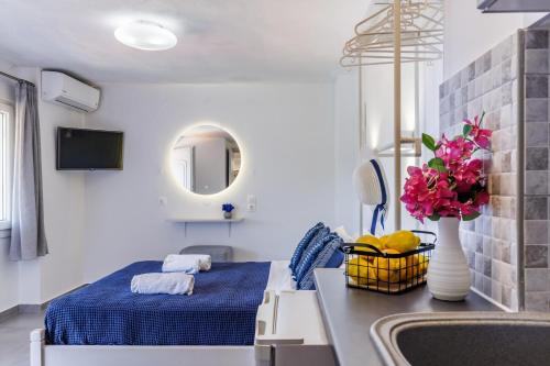 een slaapkamer met een bed en een wastafel met een vaas met bloemen bij Sea View Studios in Skopelos Town
