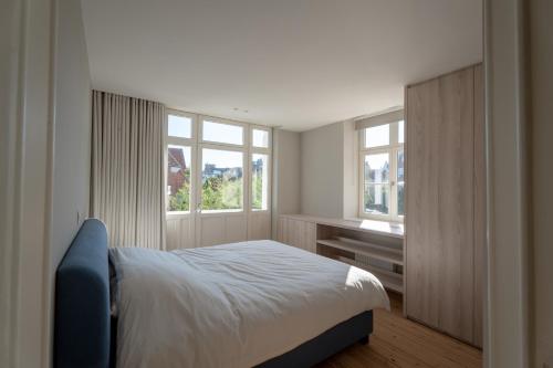 a bedroom with a bed and a window at Villa-Sabbia in Koksijde