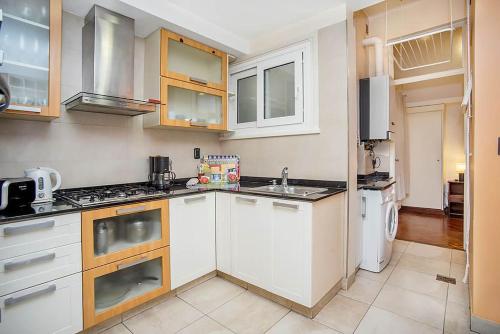 a kitchen with white cabinets and white appliances at Administracion Callao in Buenos Aires
