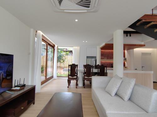 uma sala de estar com um sofá branco e uma mesa em Sense of Haiya em Chiang Mai