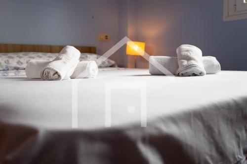 a bedroom with a bed with towels on it at Apto Galiana - En Avilés centro. in Avilés
