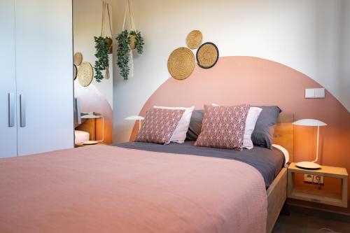 a bedroom with a large bed with two pillows at Jan Sofat LUX - 2 swimming pools - 2 bedroom Apartment Mariposa in Willemstad