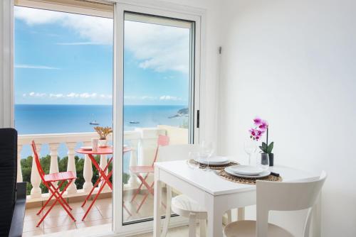 une salle à manger blanche avec vue sur l'océan dans l'établissement Somptueux 2 pièces Vue époustouflante Mer -Parking, à Roquebrune-Cap-Martin