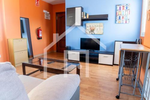 a living room with a tv and a glass table at Apto Niemeyer - Avilés centro in Avilés