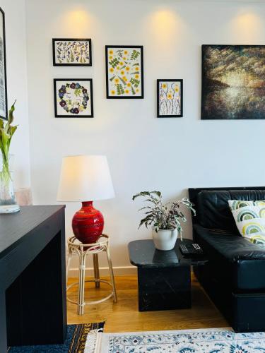 un salon avec un canapé noir et une table dans l'établissement Appartement du Petit Prince, à Meudon