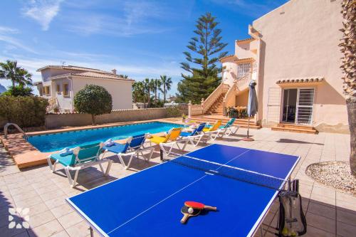 a blue ping pong table in a backyard with a pool at Villa Luna Feliz by Abahana Villas in Calpe