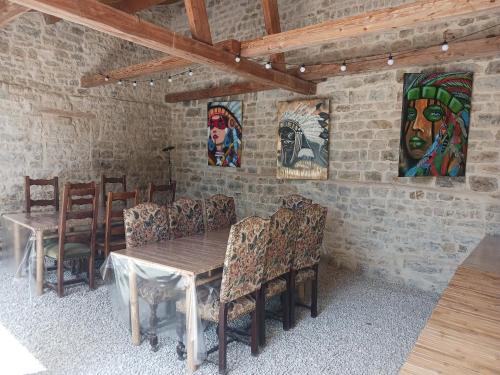 a dining room with a table and chairs and paintings at Le Couche t'Art in Pisseloup