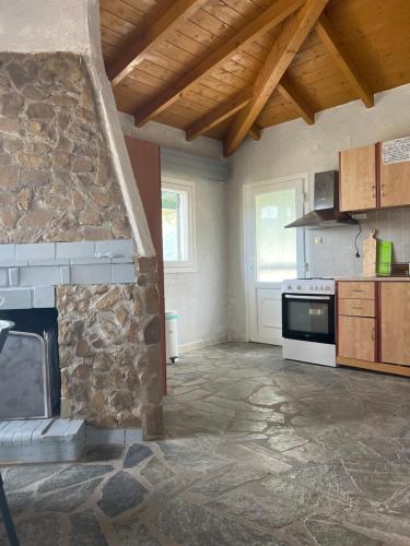 a kitchen with a stone fireplace in a room at Hamre Apartments (Nicholas) in Agios Georgios Pagon