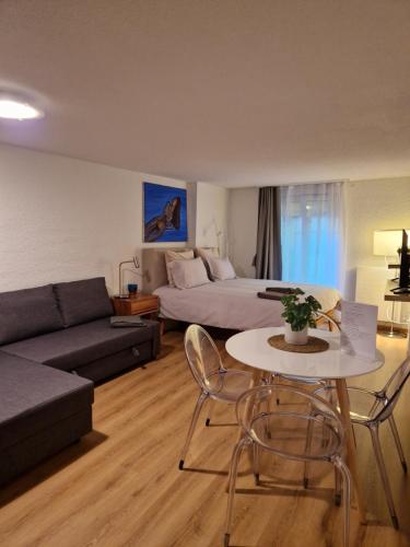 a living room with a bed and a table and a couch at Studio SIEVA in Lausanne