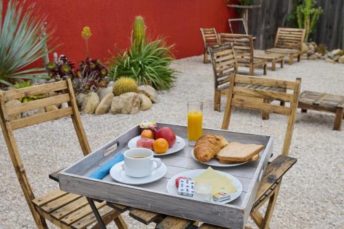 una bandeja de alimentos para el desayuno y zumo de naranja en una mesa en Hôtel Les Mimosas en Argelès-sur-Mer