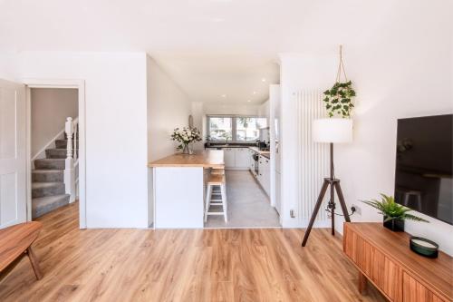 een keuken en een woonkamer met witte muren en houten vloeren bij The Camden Retreat in Londen