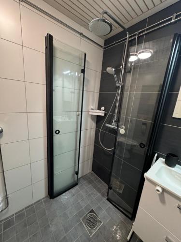 um chuveiro com uma porta de vidro na casa de banho em Syöte Huuhkamajat Cottage em Syöte