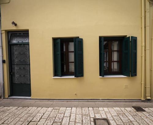 a building with green shutters and a door at Paleologou Studio in the Castle in Ioannina