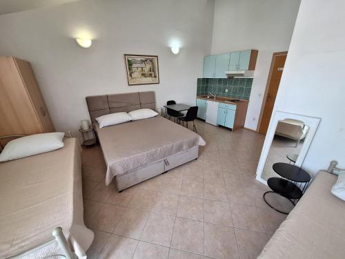 een slaapkamer met een bed en een tafel en een keuken bij Villa MANDA in Baška Voda