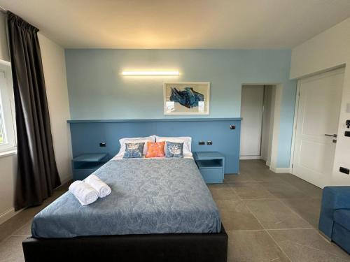 a blue bedroom with a bed with two pillows at Evergreen Laguna Vain-Lezhe in Lezhë