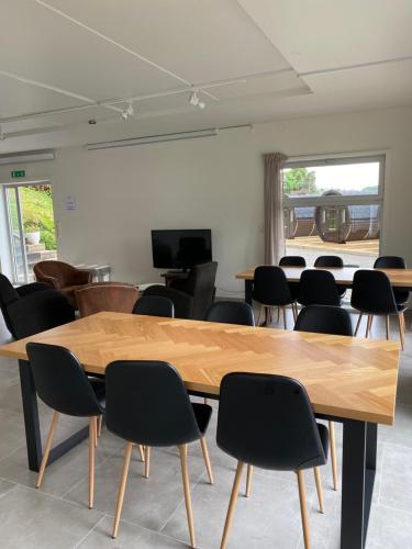 a room with a large wooden table and chairs at Sleeping barrel lodge Smaken av Ryfylke Event AS, drives ikke som hotell in Hjelmeland
