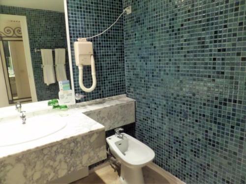 W łazience znajduje się umywalka, toaleta i lustro. w obiekcie Palm Beach Club Marmara Djerba w mieście Midun