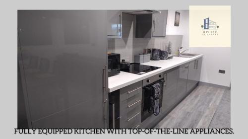 una cucina con frigorifero in acciaio inossidabile con elettrodomestici di alta qualità di Flat 407 City View Apartment a Yeadon