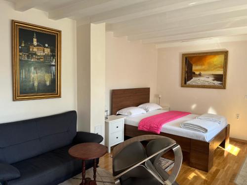 sypialnia z łóżkiem i kanapą w obiekcie ZeMoon Apartment w Belgradzie