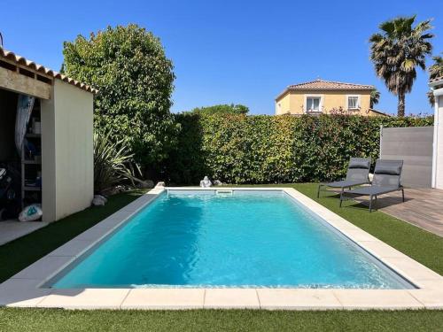 une piscine dans une cour avec une maison dans l'établissement Villa climatisée avec piscine, à Baillargues