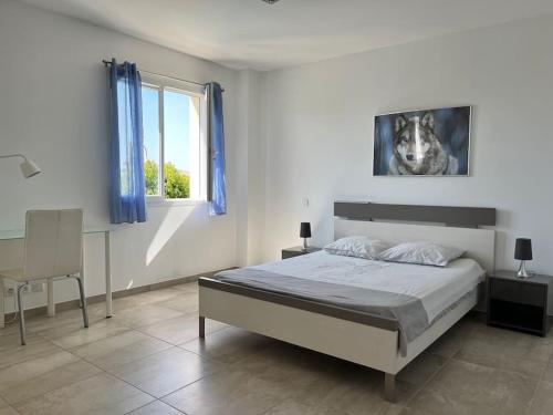 une chambre blanche avec un lit et une fenêtre dans l'établissement Villa climatisée avec piscine, à Baillargues