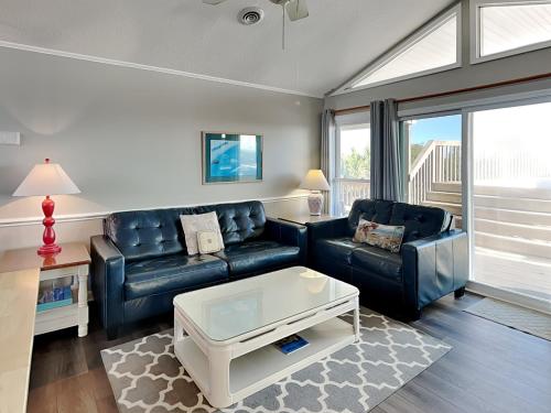 a living room with two leather couches and a coffee table at Bungalow by the Sea in Surf City