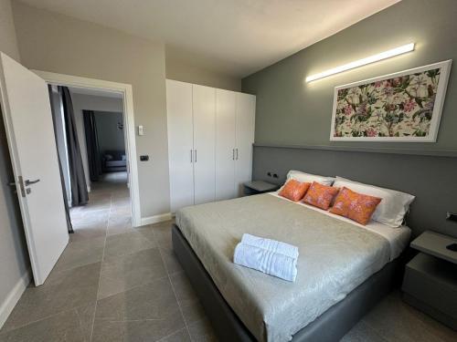 a bedroom with a large bed with orange pillows at Evergreen Laguna Vain-Lezhe in Lezhë